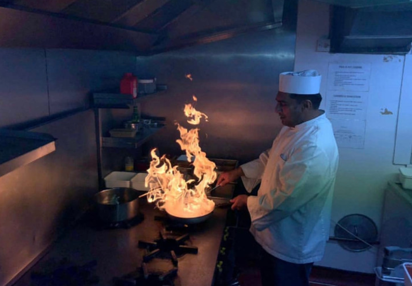 Our chef cooking over a flame in Ameen’s kitchen